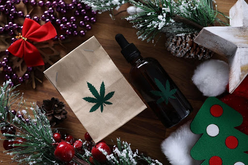 A paper bag and glass bottle with CBD leaf stickers.