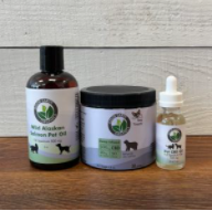 Three pet CBD products lined up on a wooden surface.